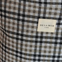 Close-up of a checkered fabric with a 'De La Mur' label.