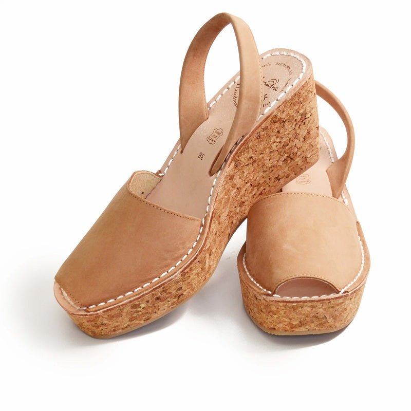 Pair of tan cork wedge sandals on a white background