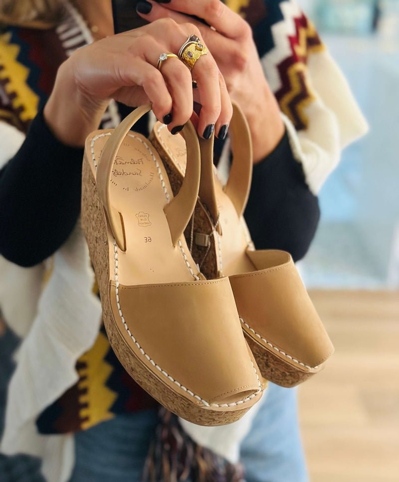 Someone holding tan cork wedges