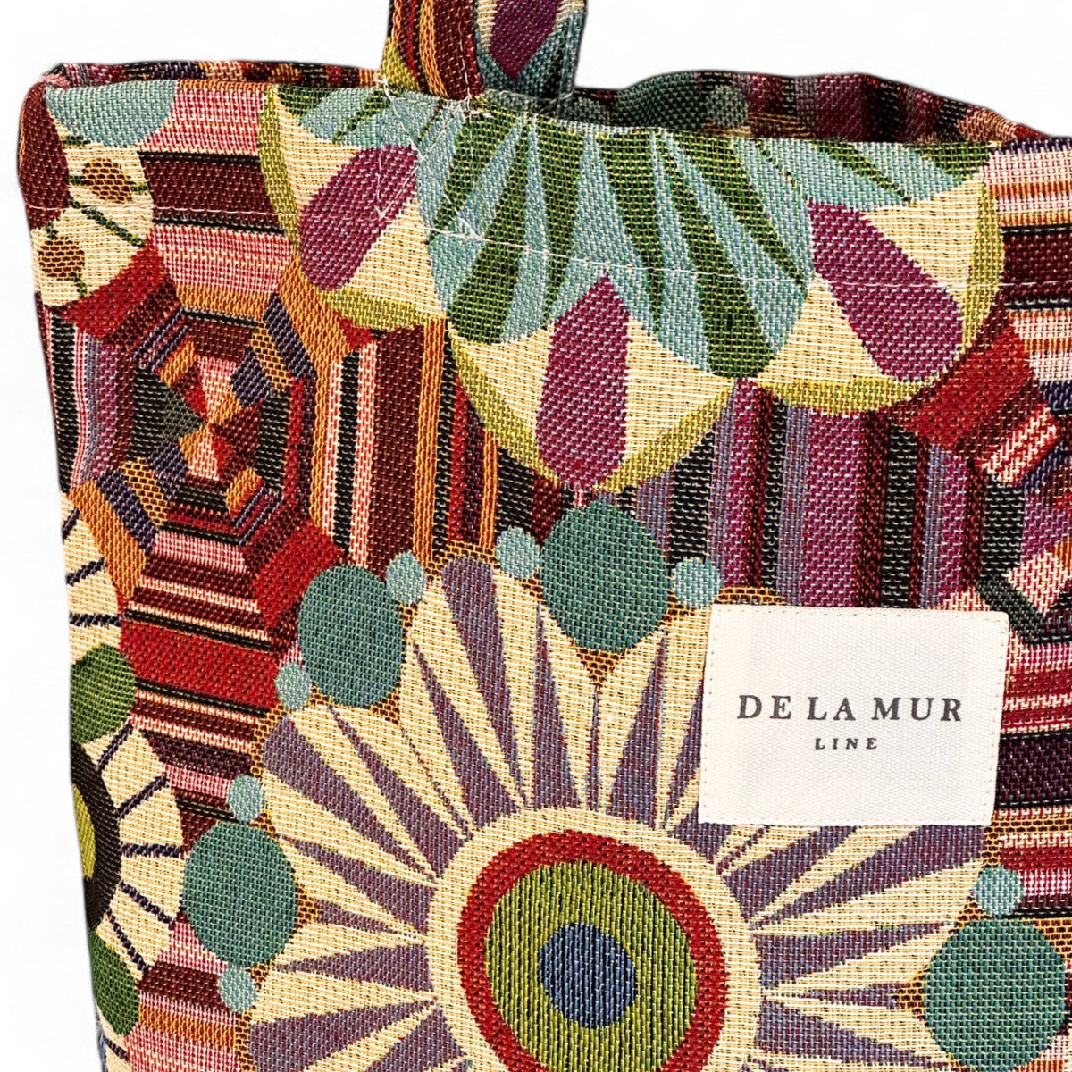Colorful patterned bag with a visible brand label on a multicolored background
