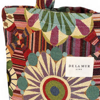Colorful patterned bag with a visible brand label on a multicolored background