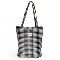 Black, white and brown checked tote bag with a visible brand label on a white background