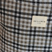 Close-up of a checkered fabric with a 'De La Mur' label.
