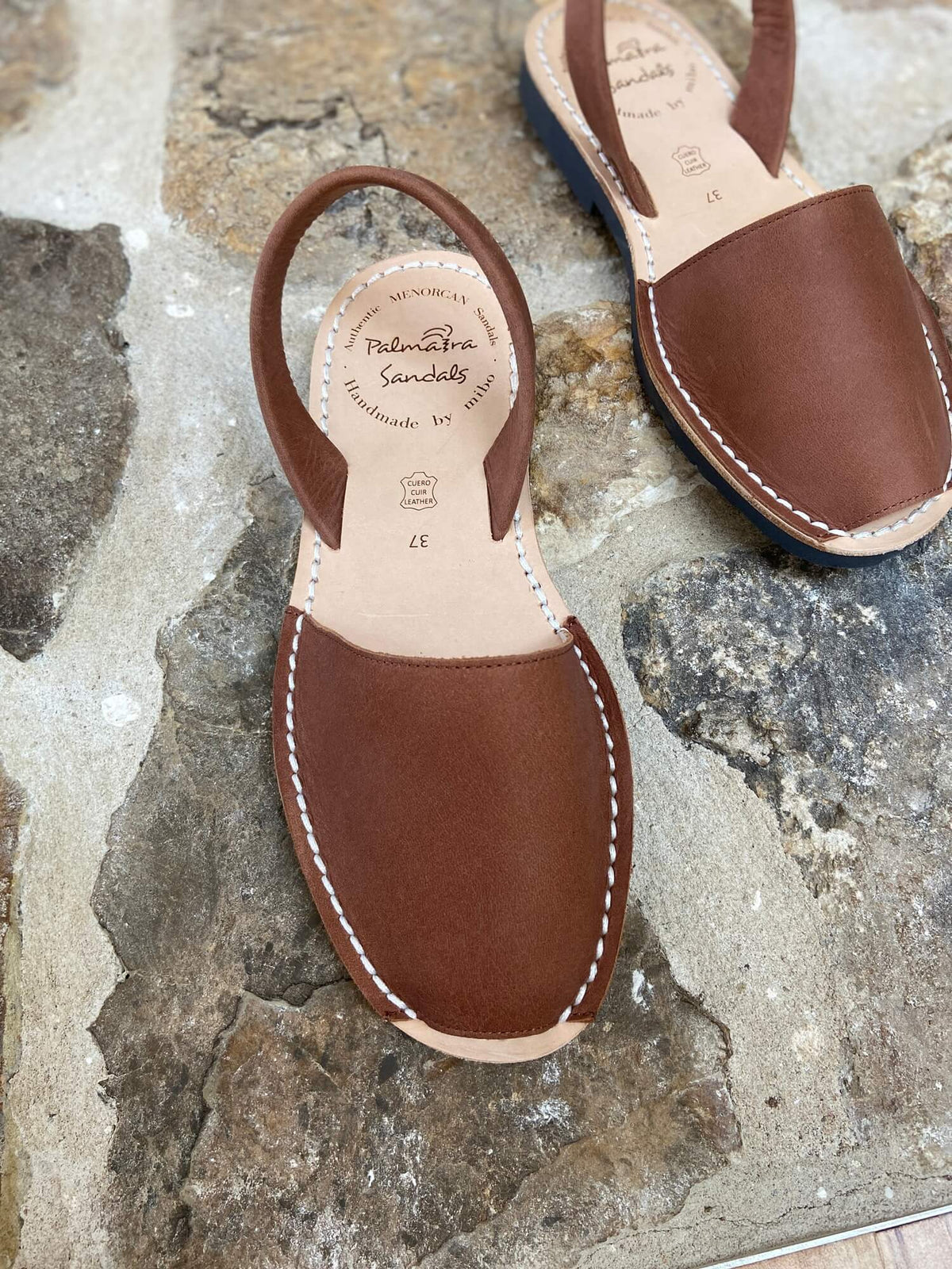 Brown leather sandals on stone