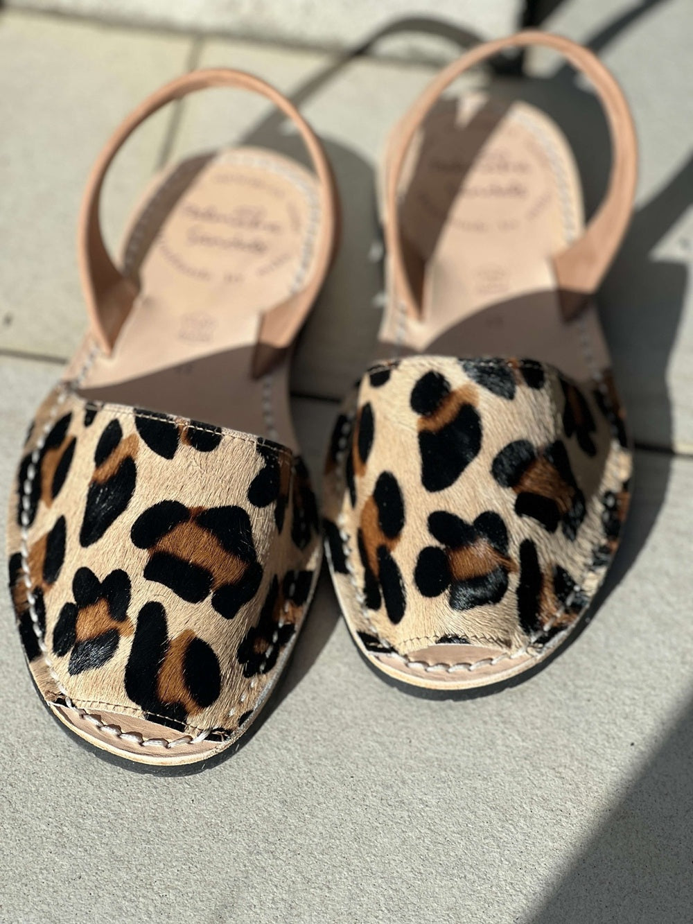 Pair of leopard print sandals on a light surface
