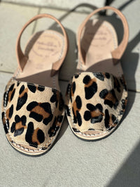 Pair of leopard print sandals on a light surface