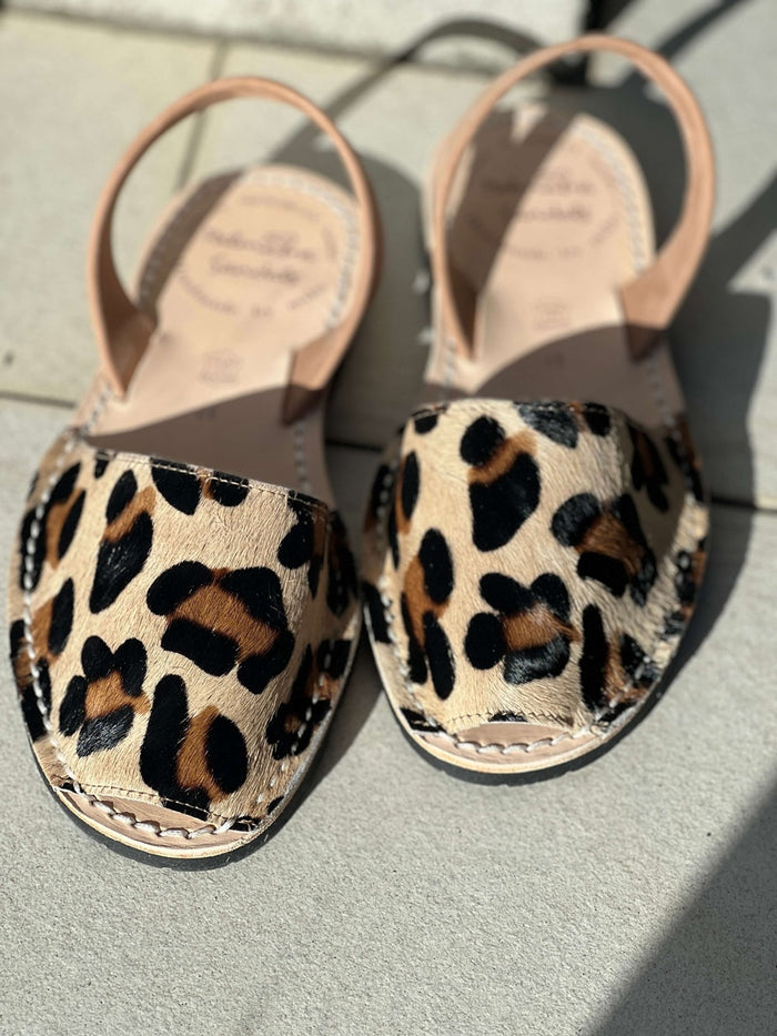 Pair of leopard print sandals on a light surface
