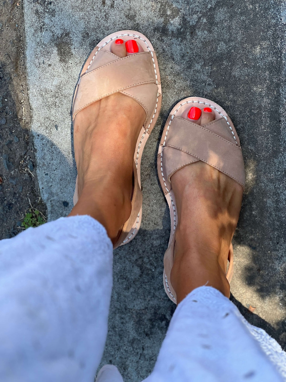 tan nubuck sandals worn on a stone surface