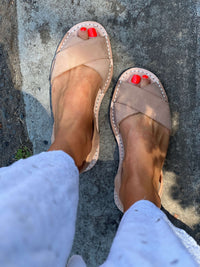 tan nubuck sandals worn on a stone surface