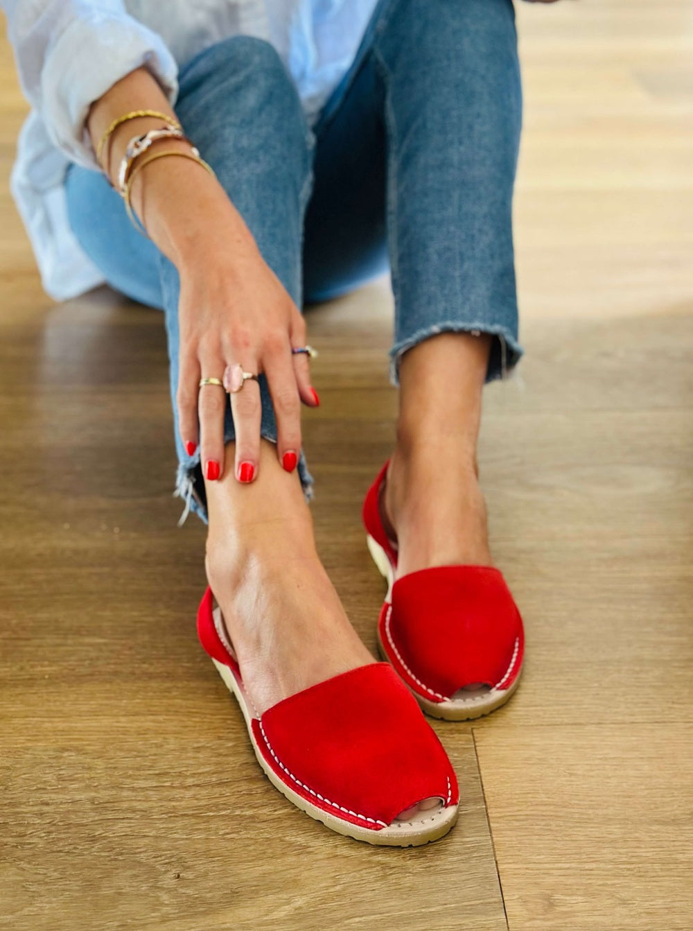 Person wearing red sandals on a wooden floor