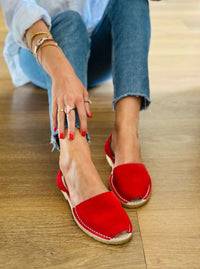 Person wearing red sandals on a wooden floor
