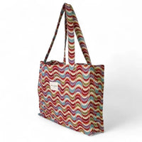 Multicolored wavy patterned tote bag on a white background