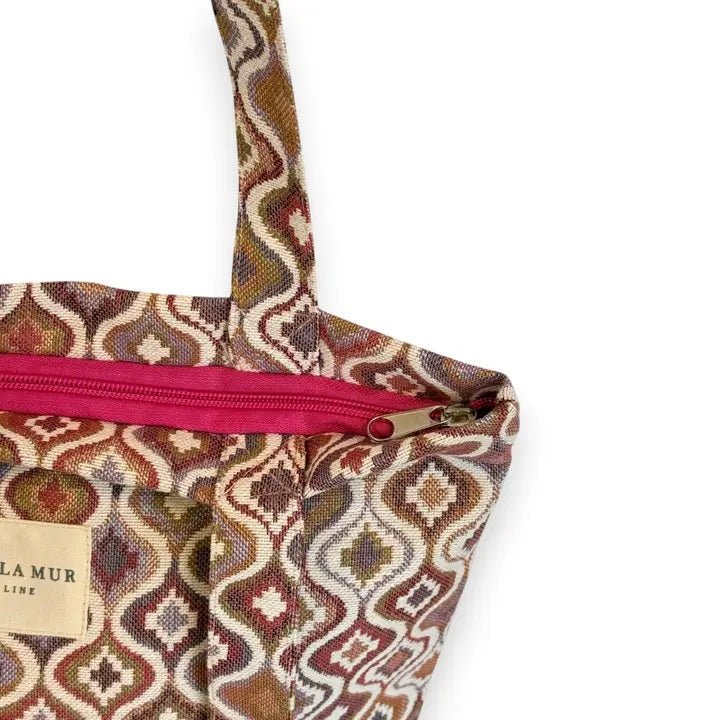 Patterned bag with a pink zipper on a white background