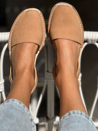 Tan avarcas worn with light blue jeans on a blurred background