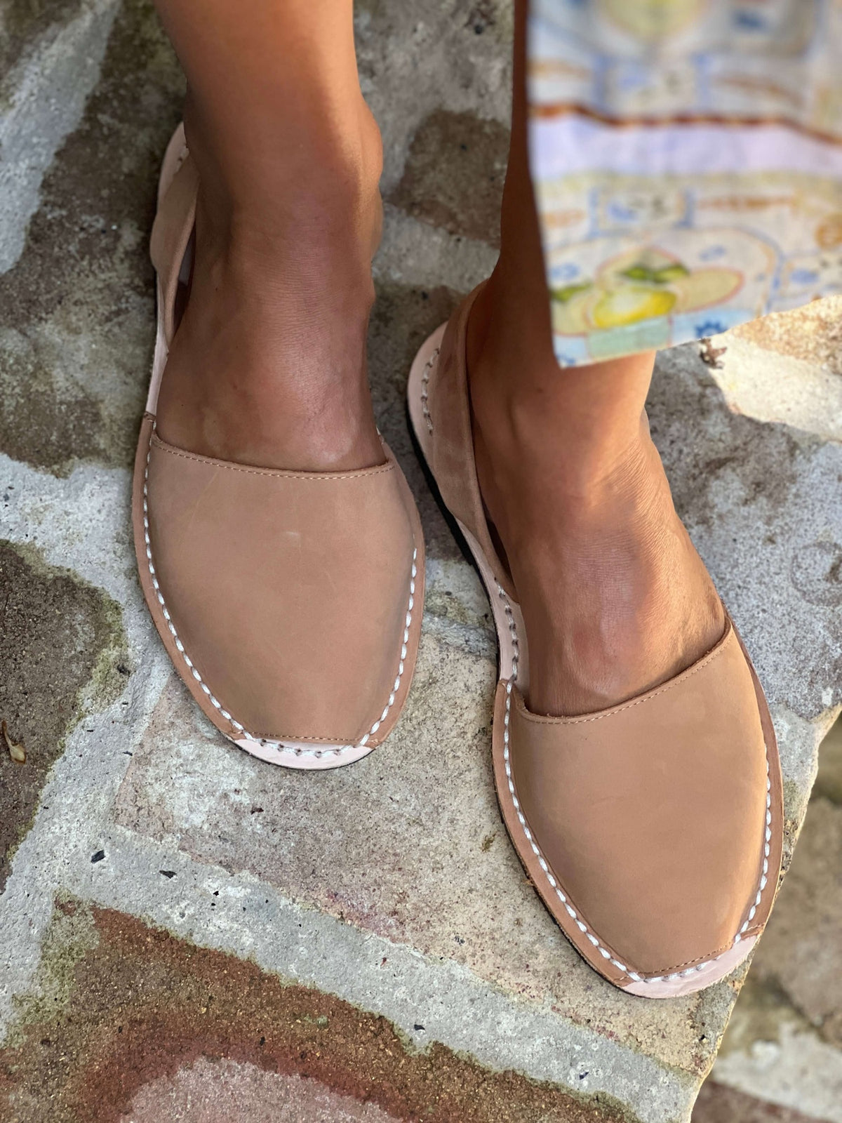 tan nubuck sandals worn on a stone surface