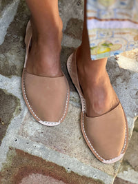 tan nubuck sandals worn on a stone surface