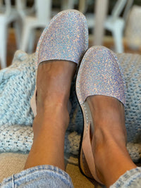 Person wearing sparkly avarcas on a textured surface